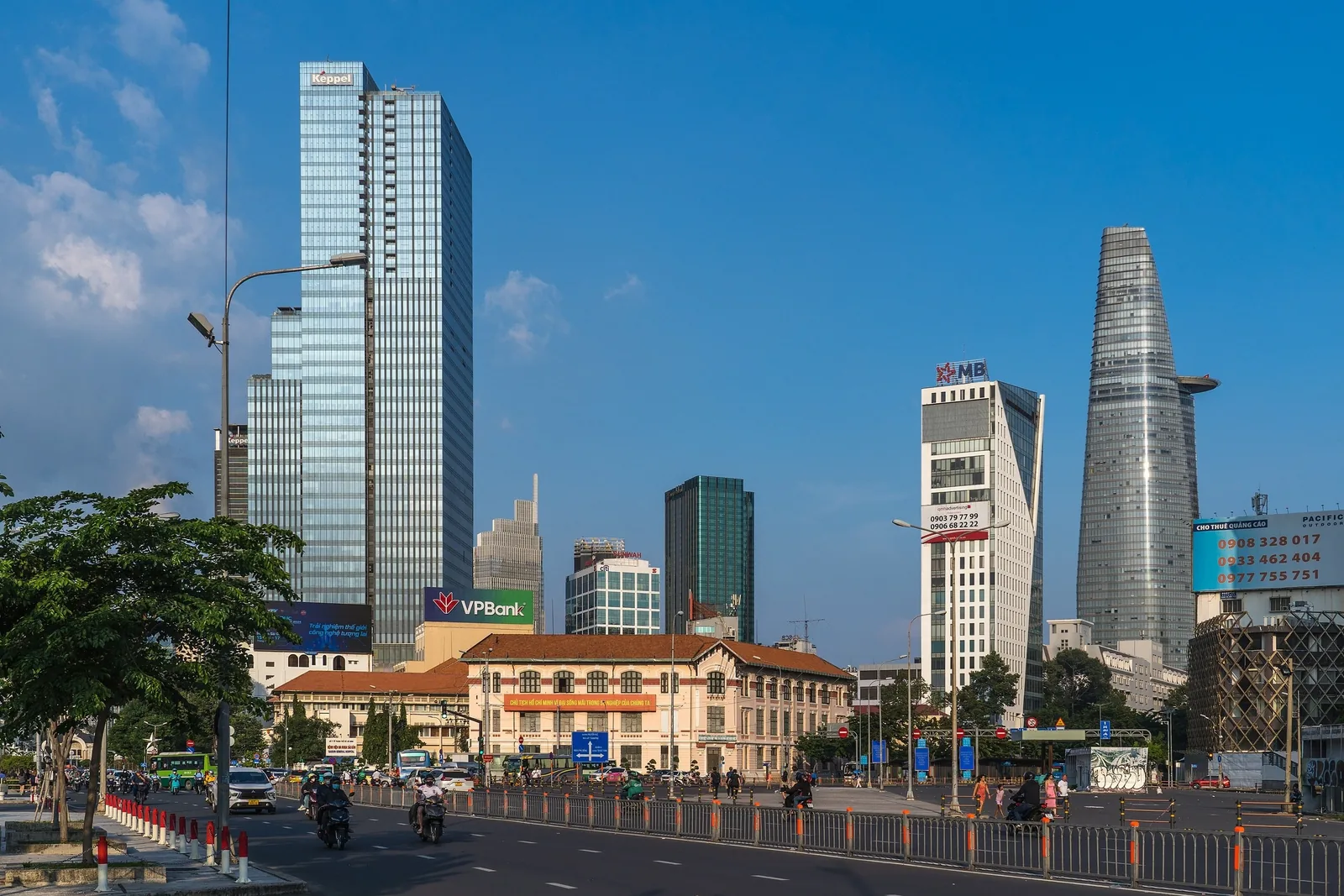 Modern skyscrapers and the Bitexco tower rise above a busy street in downtown Ho Chi Minh City.