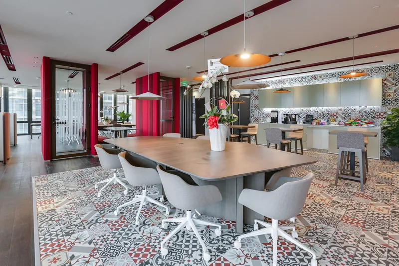 Modern meeting lounge with patterned tiles, wooden table and kitchenette in a Ho Chi Minh City office space